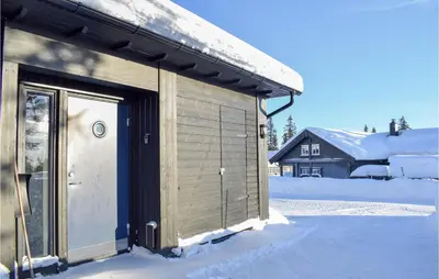 a wooden building with a door in the snow at Stunning Home In Sjusjøen With Sauna in Sjusjøen