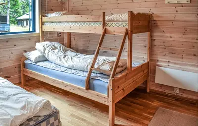 a bedroom with two bunk beds in a log cabin at Stunning Home In Sjusjøen With Sauna in Sjusjøen