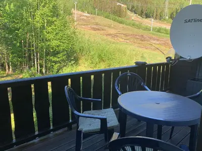 a table and chairs sitting on a deck with a view at Norefri apartment with sauna at Nedre Norefjell Ski In- Ski Out in Noresund