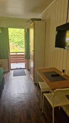 a room with a table and a table and a kitchen at Kvamsdal Pensjonat 3 in Eidfjord