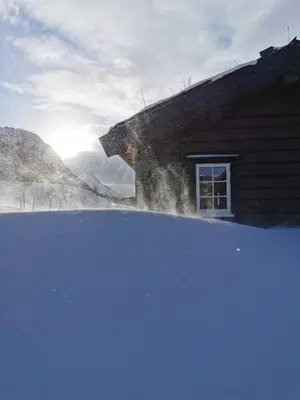 a snow covered roof of a house with a window at STORHAUGEN GARD in Lom