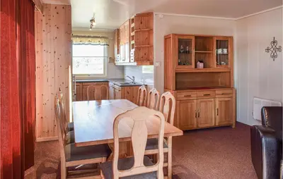 a kitchen with a wooden table and wooden cabinets at Leil Nr 32 in Sjusjøen