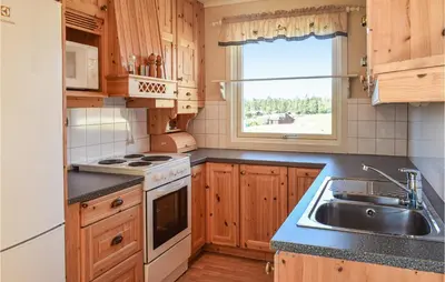 a kitchen with wooden cabinets and a sink and a window at Leil Nr 32 in Sjusjøen