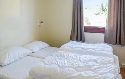 an unmade bed in a room with a window at Leil Nr 32 in Sjusjøen
