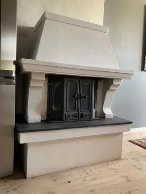 a fireplace in a kitchen with a stove at Moldegaard Farmhouse - Apartment A in Moldegard