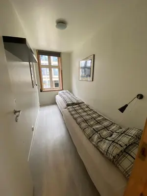 a bedroom with a bed in the corner of a room at Nice central appartment in Bergen