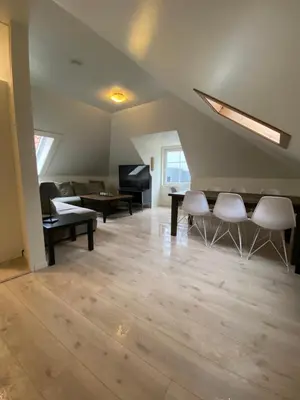a living room with a couch and a table and chairs at Nice central appartment in Bergen