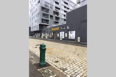 an empty street with a green fire hydrant in front of a building at Nice central appartment in Bergen