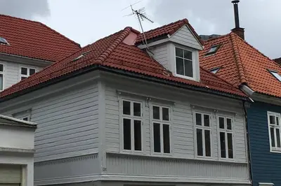 a house with a red roof and some buildings at Nice central appartment in Bergen