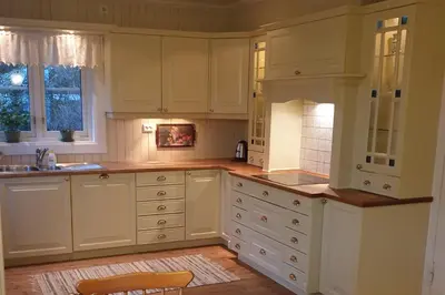 a kitchen with white cabinets and a sink at Irenegarden - Fjord view holiday home in Lauvstad