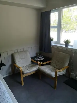 a room with two chairs and a table and a window at Kvamsdal Pensjonat 4 in Eidfjord