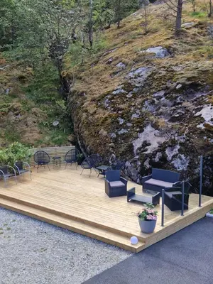 a wooden deck with chairs and a table and chairs at Kvamsdal Pensjonat 4 in Eidfjord
