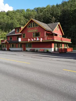a red building on the side of a road at Kvamsdal Pensjonat 4 in Eidfjord