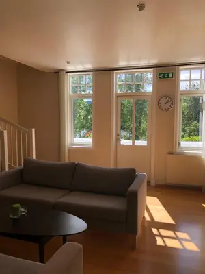 a living room with a couch and a clock on the wall at Villa Sole, Trysil in Trysil