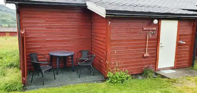 a small red shed with a table and chairs at Midtgard in Tyinkrysset