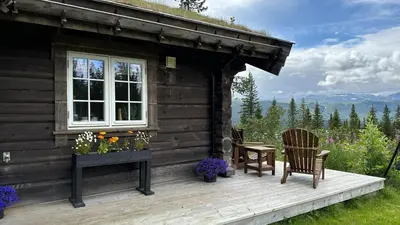 a cabin with two chairs and a table and a window at Liaplassen Mountain View in Beitostøl