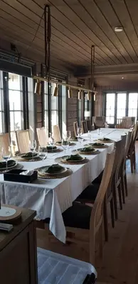 a long dining room with a long table and chairs at Mjøshytte in Stange