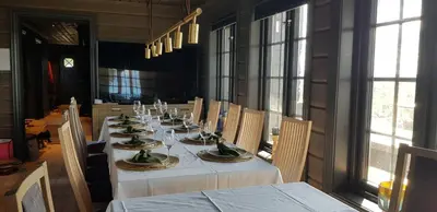 a dining room with a long table with white table cloth at Mjøshytte in Stange