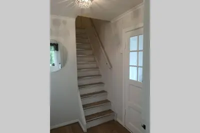 a staircase in a home with a chandelier at Reinebu in Ørsta