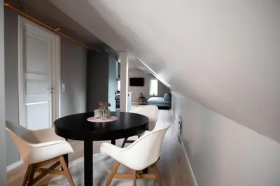a dining room with a black table and white chairs at Trolltunga Odda Apartments in Odda