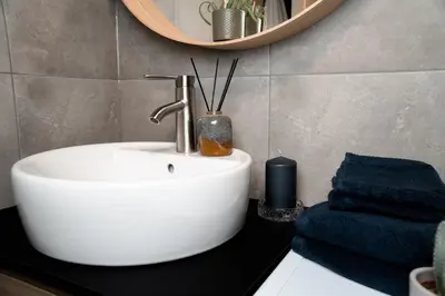 a bathroom with a white sink and a mirror at Trolltunga Odda Apartments in Odda
