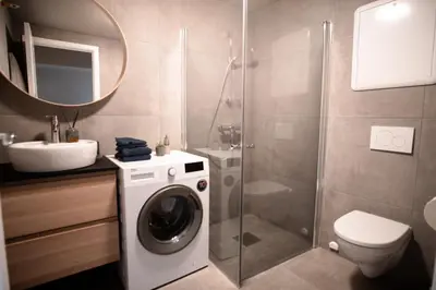 a bathroom with a washing machine and a sink at Trolltunga Odda Apartments in Odda