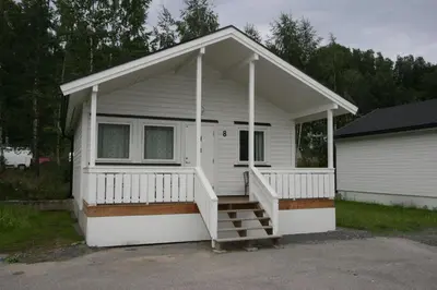 a small white house with a porch and stairs at Lillehammer Camping in Lillehammer