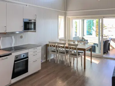 a kitchen and dining room with a table and chairs at 6 person holiday home in Dyrvik in Dyrvik