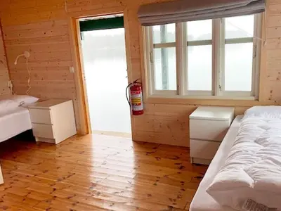 a bedroom with a bed and two windows and a wooden floor at 6 person holiday home in LINDÅS in Lindås