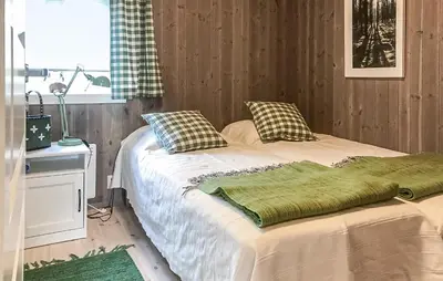 a bedroom with two beds and a window at Moltebæret in Skåbu