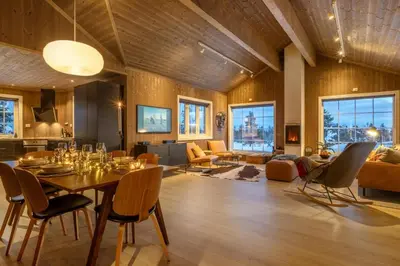 a dining room and living room with a table and chairs at Villa Budor - 60 min fra OSL - Jaccuzzi - 4 soverom in Nordset
