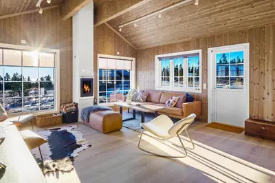 a living room with a couch and a table at Villa Budor - 60 min fra OSL - Jaccuzzi - 4 soverom in Nordset