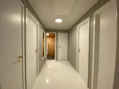 a hallway with white floors and white doors at Askevika in Vikum