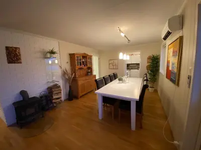 a kitchen and dining room with a white table and chairs at Askevika in Vikum