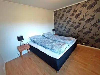 a small bedroom with a bed and a night stand at Leinastova in Sandshamn