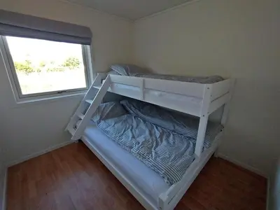 a white bunk bed in a room with a window at Leinastova in Sandshamn