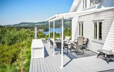 a wooden deck with a table and chairs on a house at 3 Bedroom Awesome Home In Skjold in Skjold