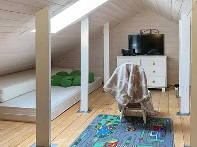 a attic room with a bed and a crib at Seaside Serenity in Hardangerfjord-By Traum in Tyrvikbygd