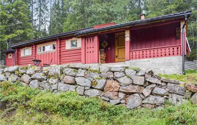 a red cabin behind a stone wall at Høgesset in Feiring