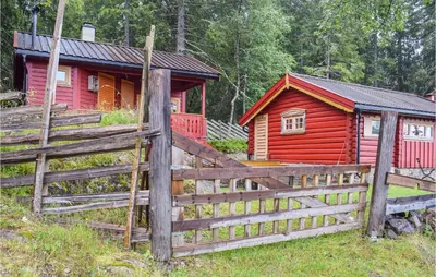 a wooden fence in front of a red cabin at Høgesset in Feiring