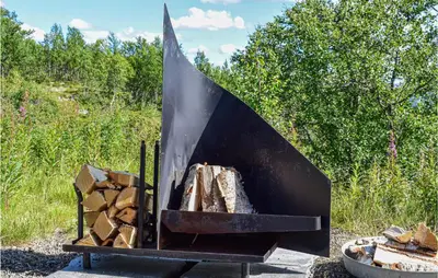a fire pit with a pile of fire wood at 3 Bedroom Amazing Home In Uvdal in Uvdal