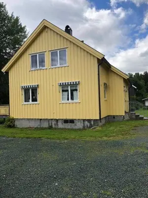 a yellow house with two windows on the side of it at Sjarmerende overnatting sentralt i Vest-Telemark in Høydalsmo
