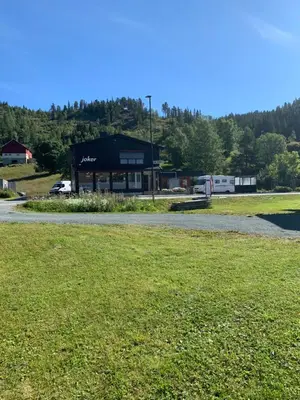 a parking lot with a building in the background at Sjarmerende overnatting sentralt i Vest-Telemark in Høydalsmo