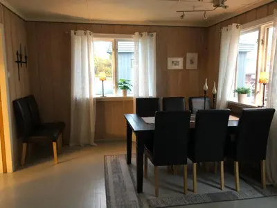 a dining room with a table and black chairs at Sjarmerende overnatting sentralt i Vest-Telemark in Høydalsmo