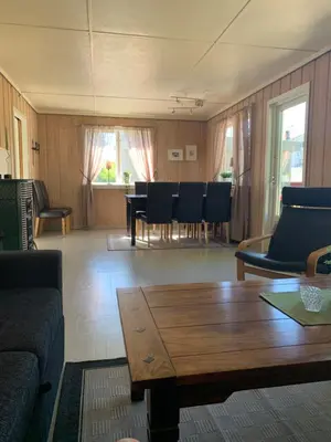 a living room with a couch and a table and chairs at Sjarmerende overnatting sentralt i Vest-Telemark in Høydalsmo