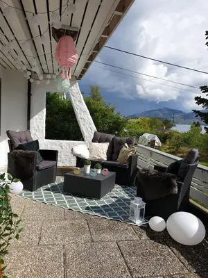 a patio with couches and tables and a view at Bergen Apartment with Fjord View in Isdalsstø