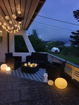 a patio with a table and chairs on a roof at Bergen Apartment with Fjord View in Isdalsstø