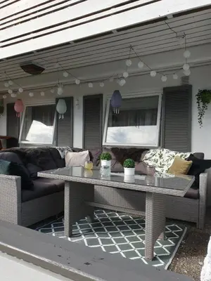 a table and a couch on a patio at Bergen Apartment with Fjord View in Isdalsstø