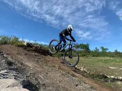 a person riding a bike on a dirt road at Ramsbu utsikt terasse selvhushold in Hovden