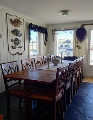 a dining room with a wooden table and chairs at Marthas Rorbu in Bakkasund
